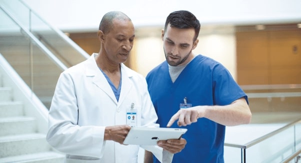 ein paar &Auml;rzte, die auf ein Tablet schauen