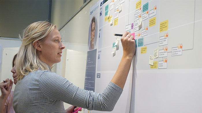 eine Frau, die auf ein Whiteboard schreibt