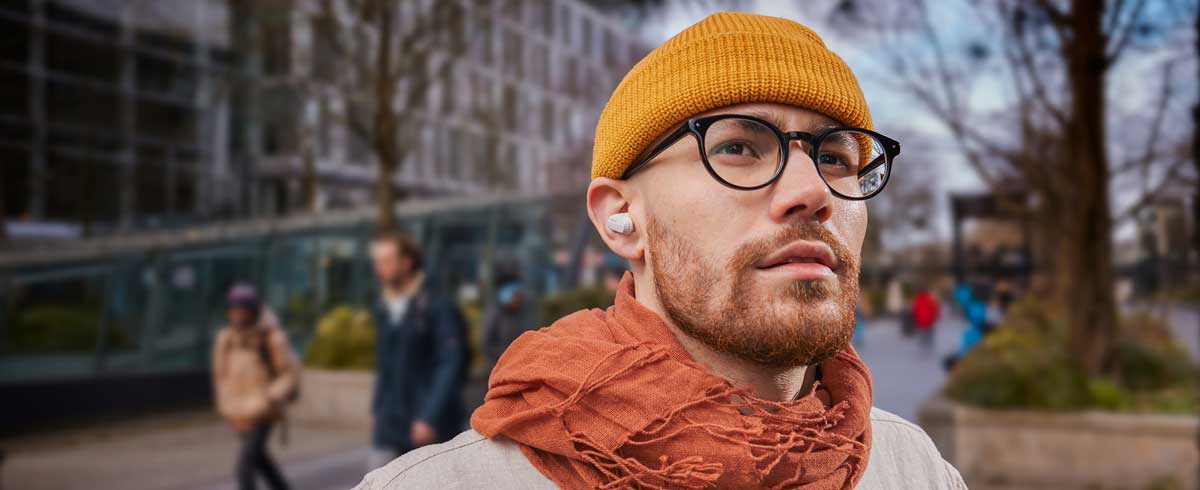Nahaufnahme eines Mannes, der echte kabellose Kopfh&ouml;rer tr&auml;gt